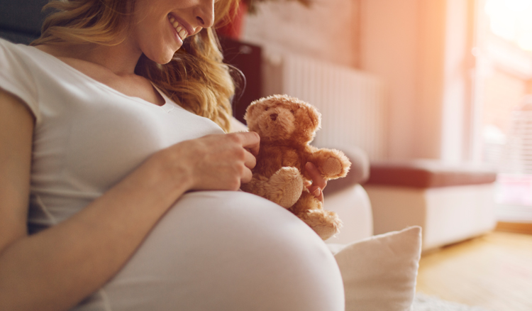 Schwangere Frau mit Teddybär